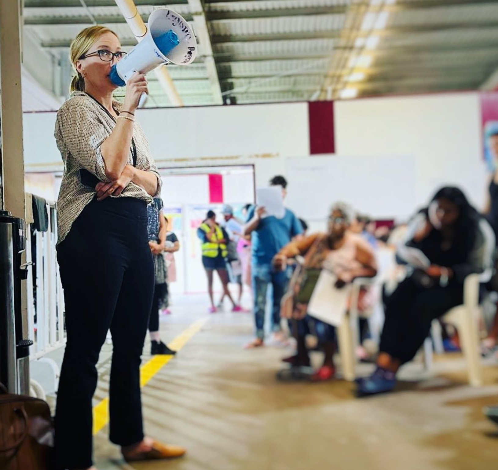 Woman holding a megaphone talking to a large group